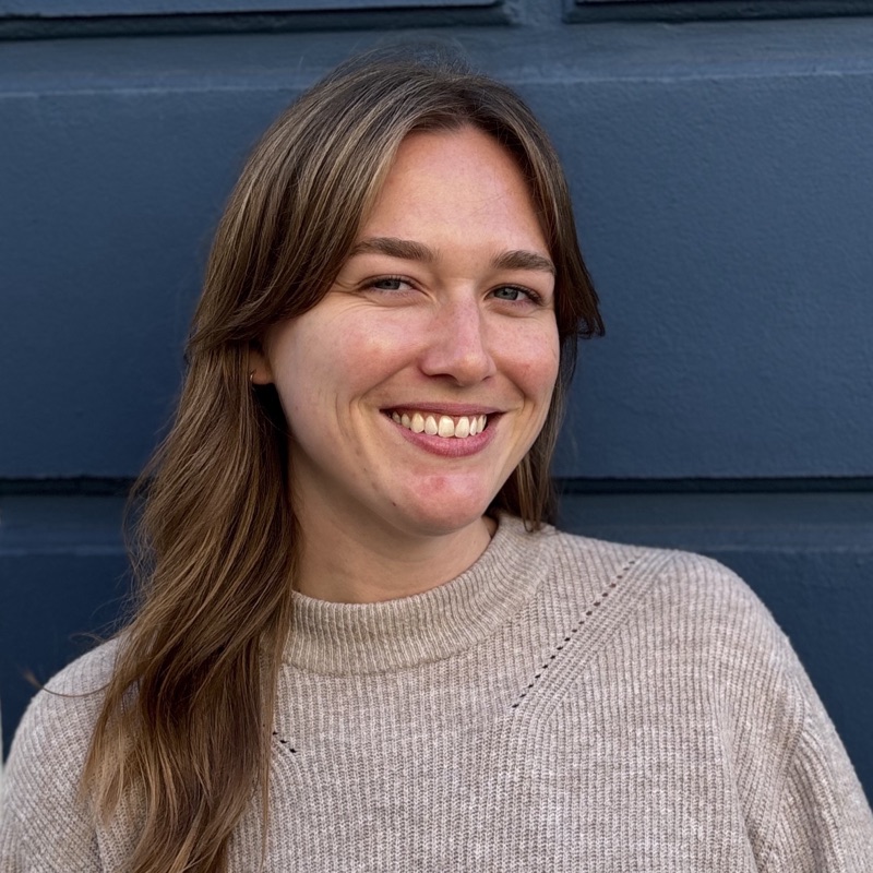 Kate Bosen smiling in front of a blue wall