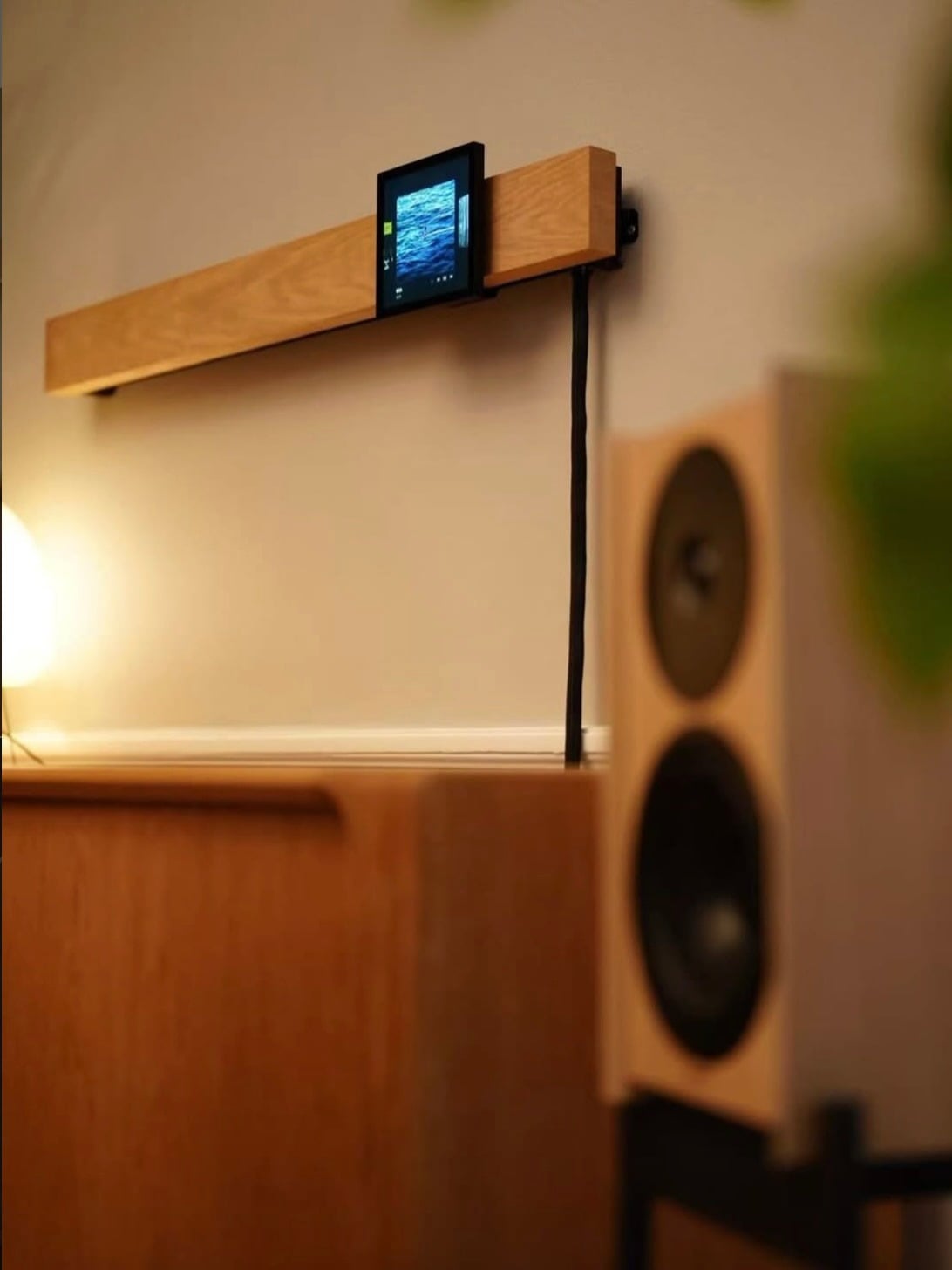 Wall-mounted display and speaker prototype in a living room setting
