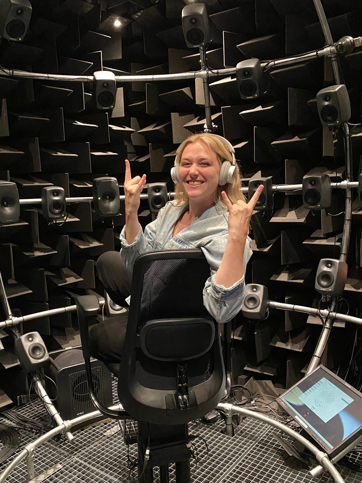 Kate Bosen inside a spherical spatial audio testing rig, wearing headphones