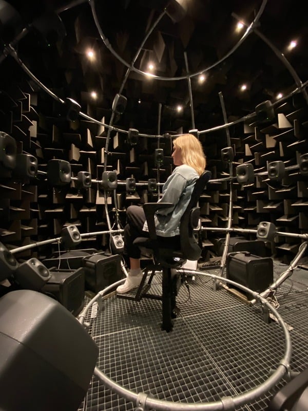 Kate Bosen seated inside a spherical spatial audio testing rig