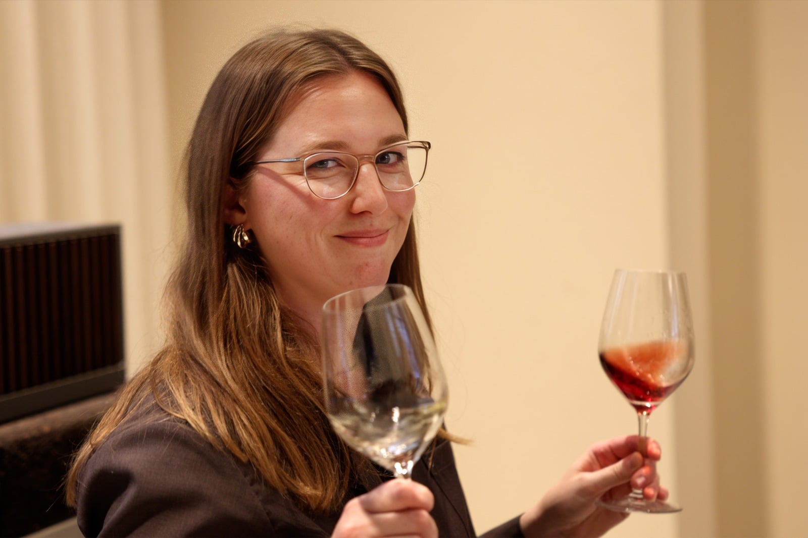 Kate Bosen holding a glass of white wine and a glass of red wine
