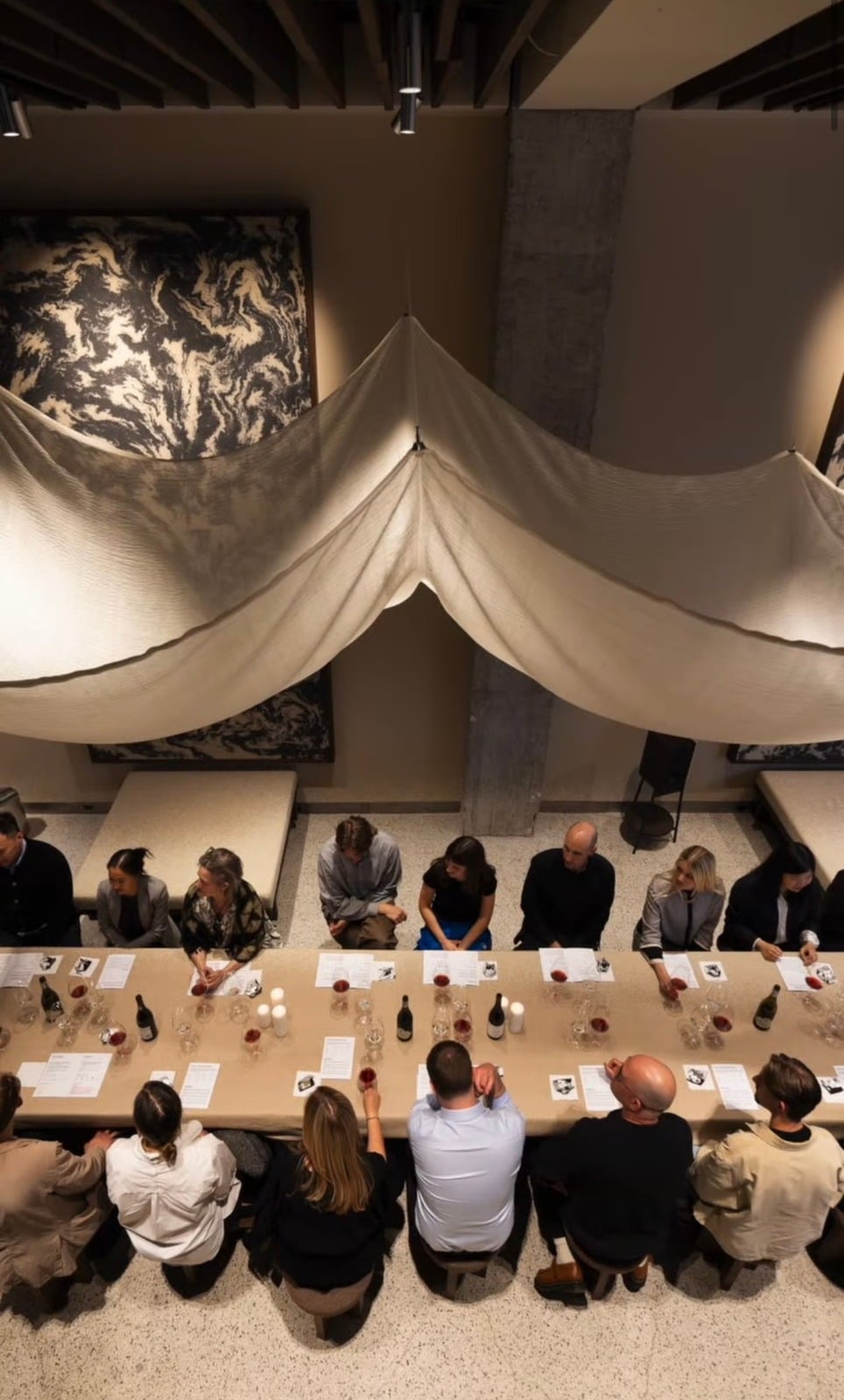 Overhead view of a wine tasting event with guests seated at a long table
